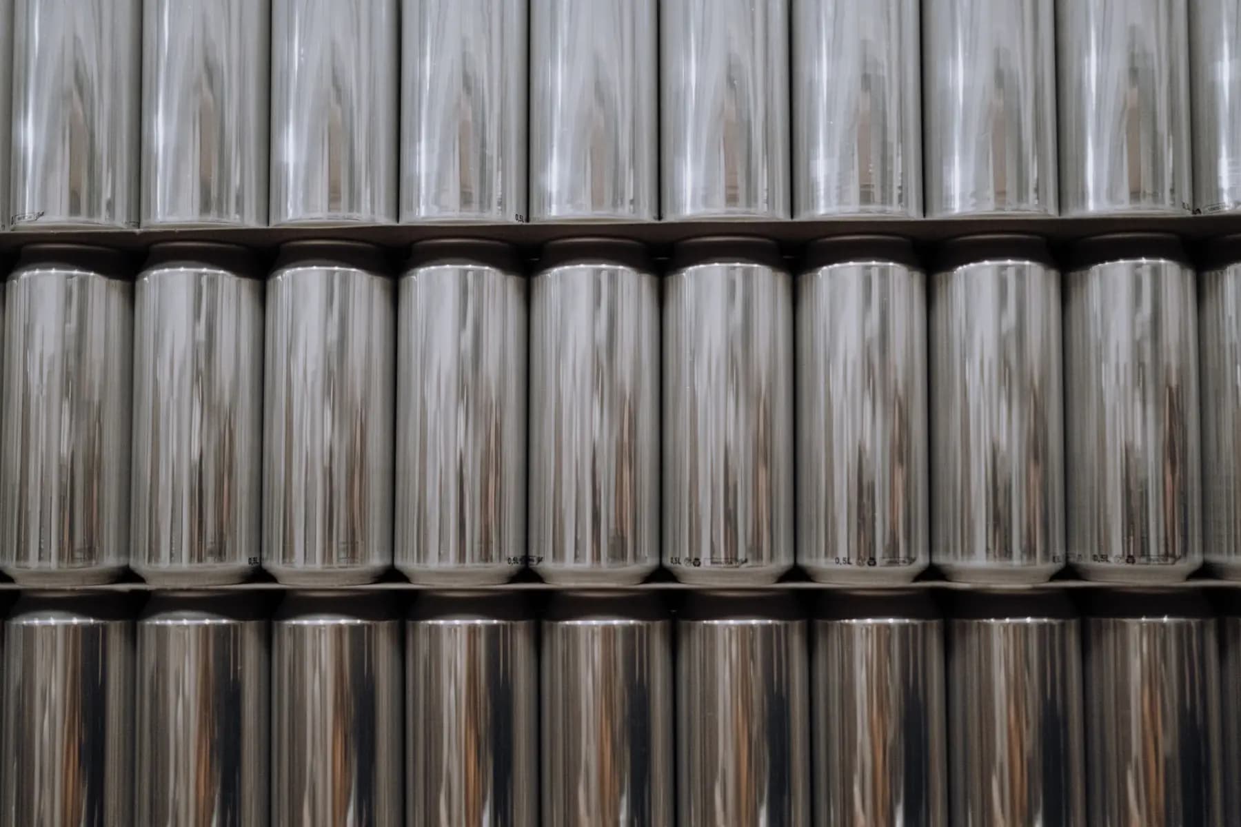 Rows of plain aluminium cans stacked on their sides